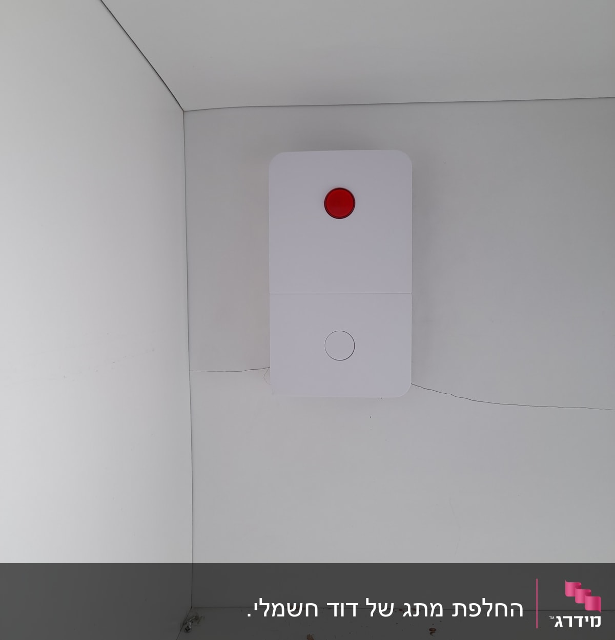 לחצן חירום אדום על קיר לבן